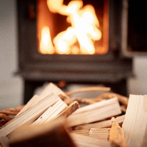 Some firewood with the fireplace in the background