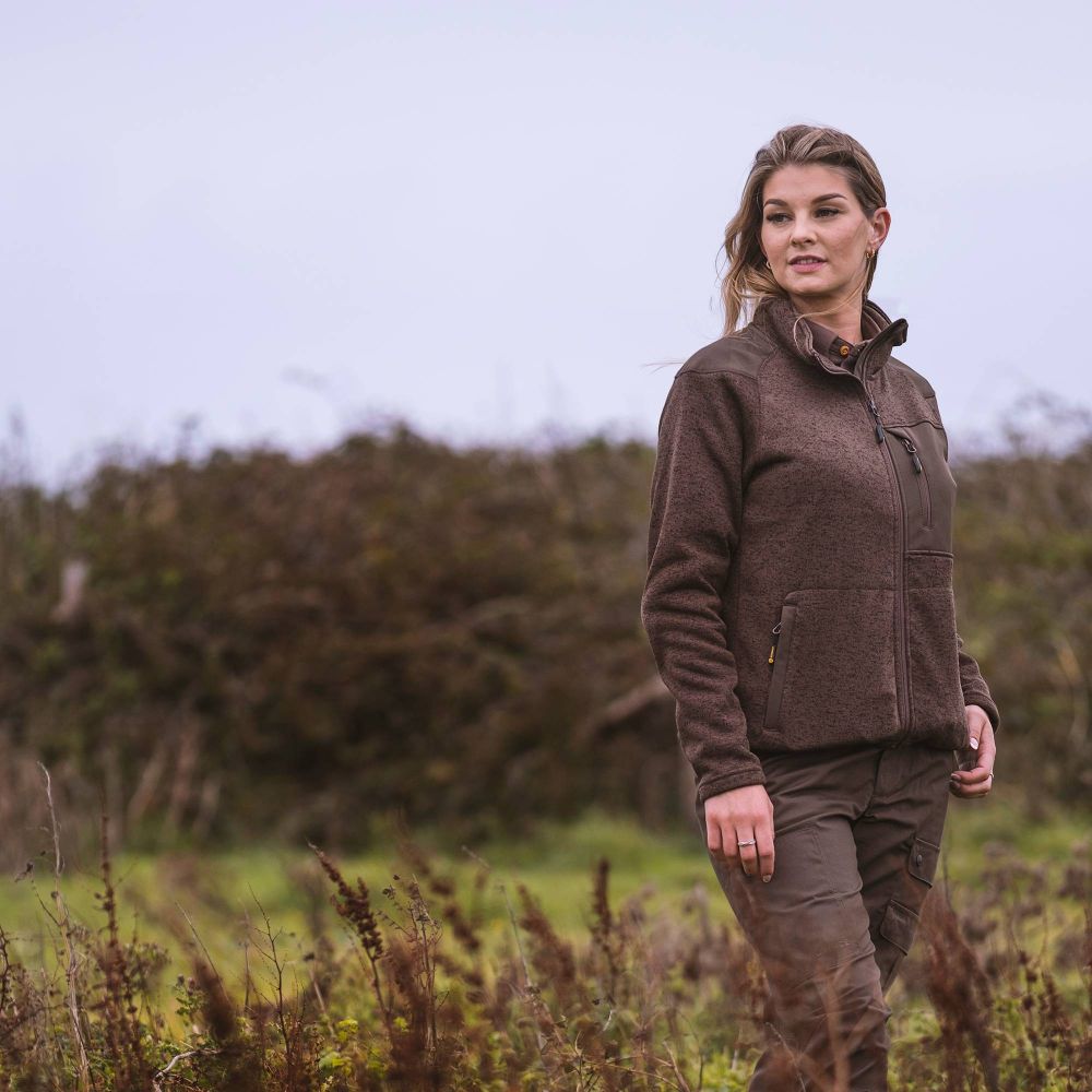 Woman in hunting gear stood in a field