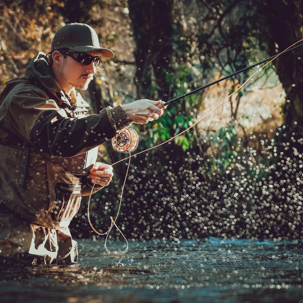 Action shot of a man fly fishing in a river