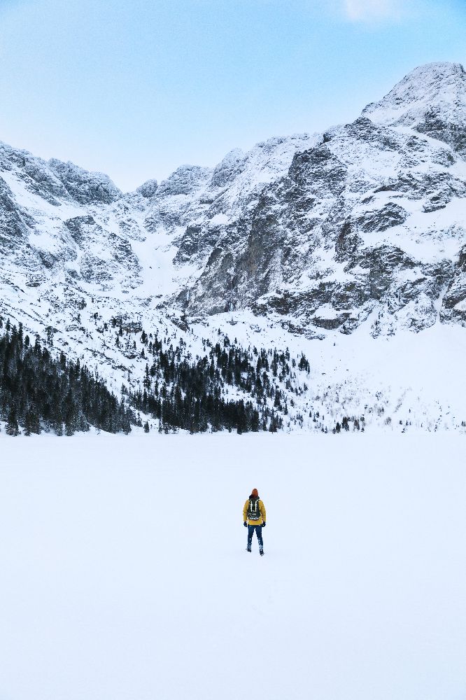 A man stood in contrast to a background of snow